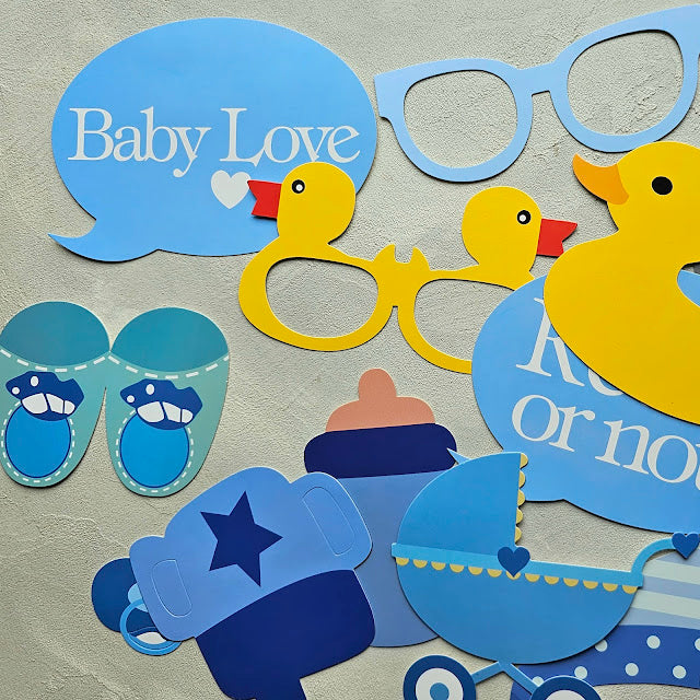Rekvisita i blått för babyshower, bland annat anka, nappflaska och skor