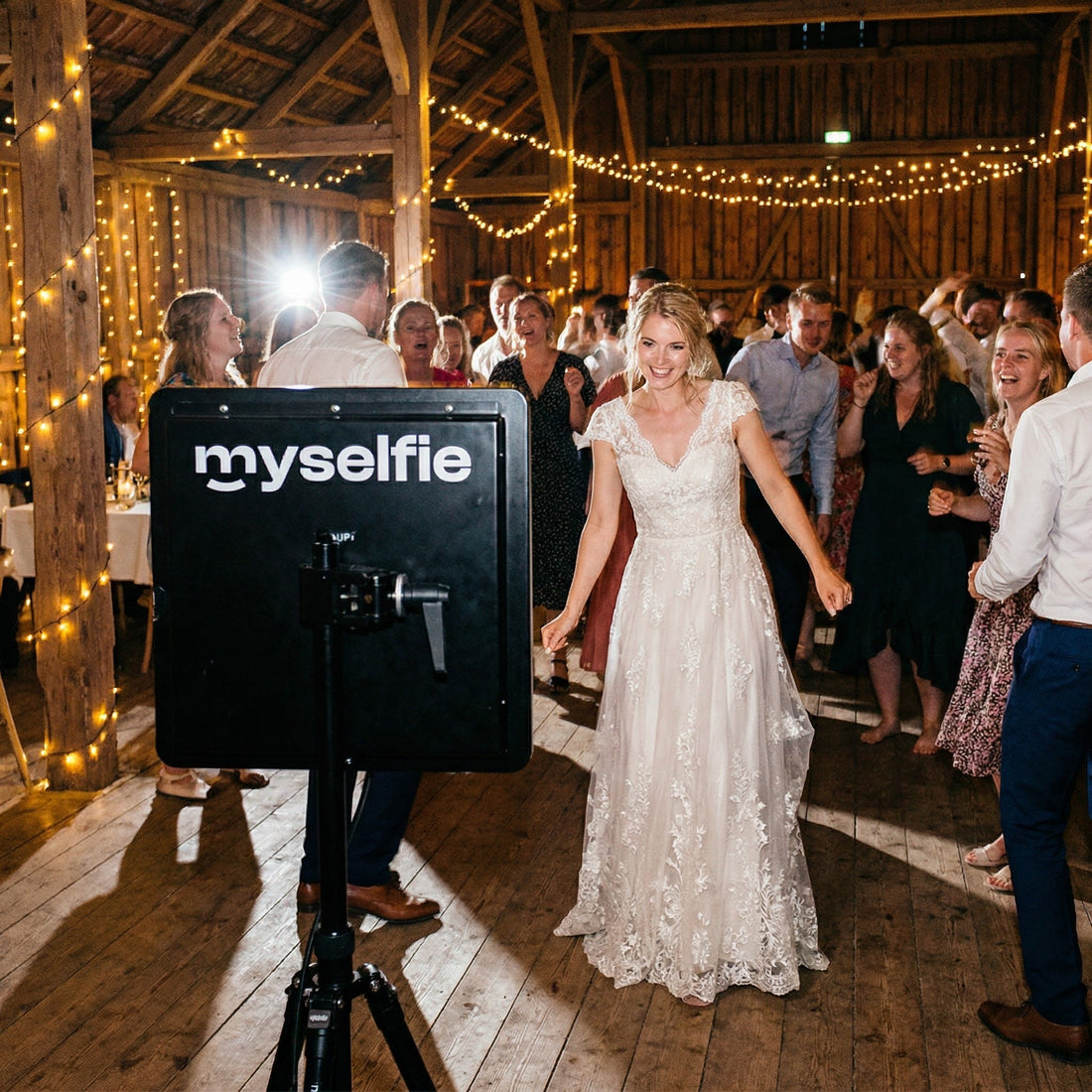 Brud dansar på dansgolvet i en ladugård bredvid en Myselfie fotobås