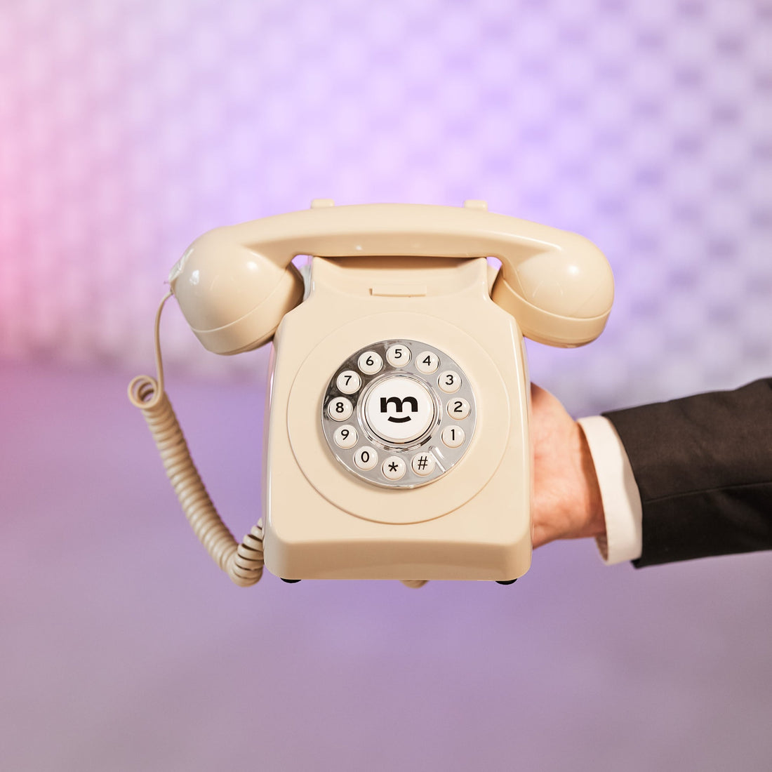 Hand håller en beige retrotelefon som fungerar som ljudgästbok